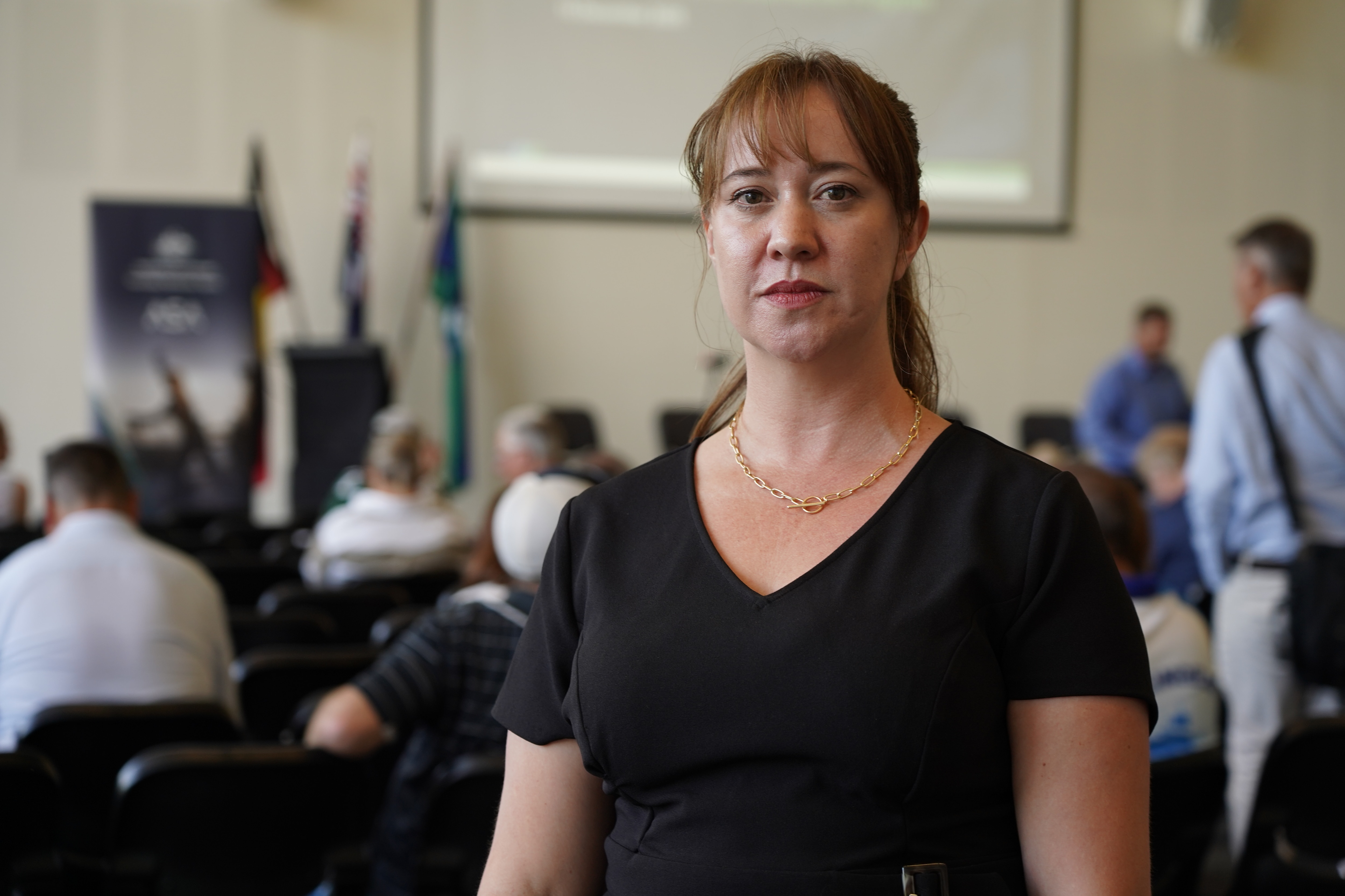 Uma foto intermediária de Latoya Voogt, moradora de Rockingham, posando para uma foto dentro de casa com um top preto.