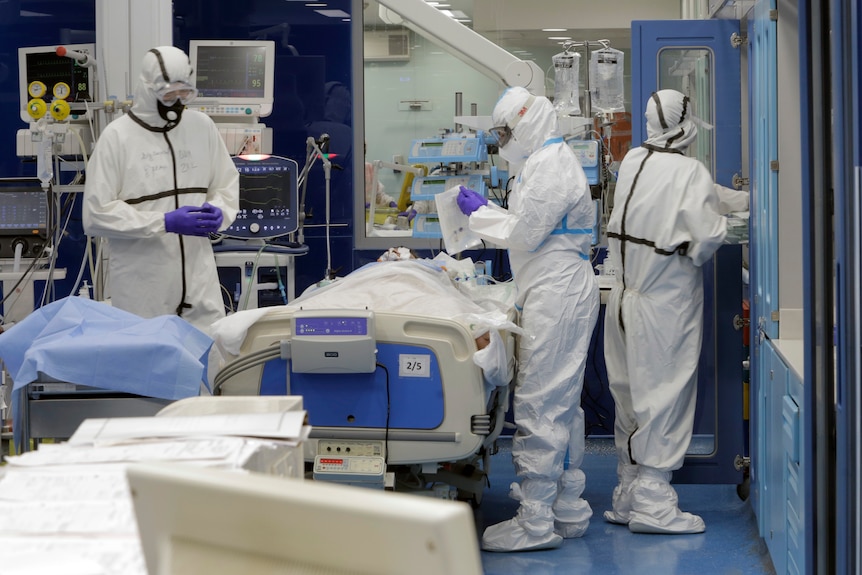 Lucrătorii din domeniul sănătății din echipamentele individuale de protecție (EIP) îngrijesc pacientul 