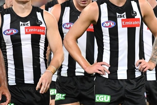 A tightly cropped image of Collingwood players in their black and white striped jerseys