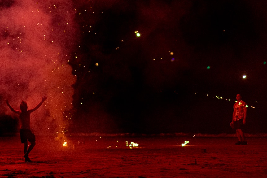 Mindil Beach is swarmed by people letting off fireworks from the sand.