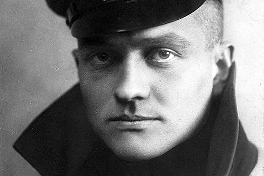 Portrait of a German WW1 pilot wearing a cap and with a medal on his shirt.