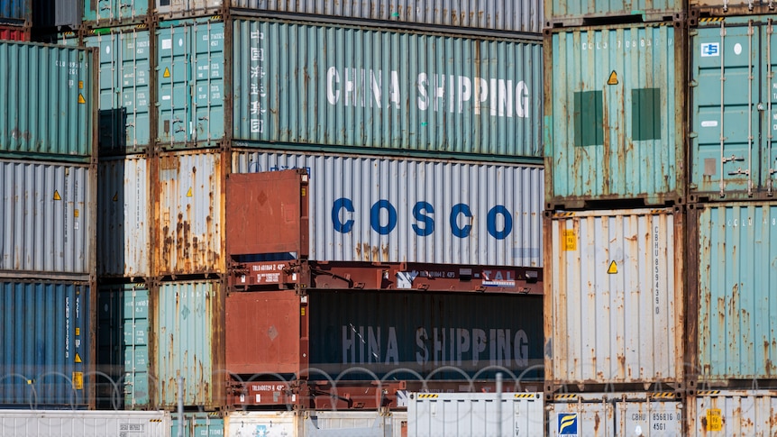 Shipping containers stacked up with logos for China Shipping and Cosco on them