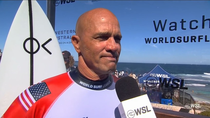 Kelly Slater looks emotional while speaking to a World Surf League interviewer.