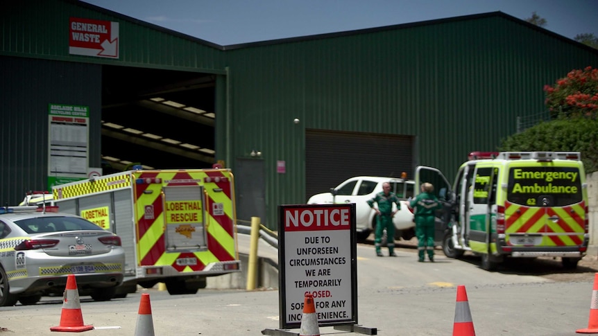 A larged shed with a fire truck, a police car and an ambulance