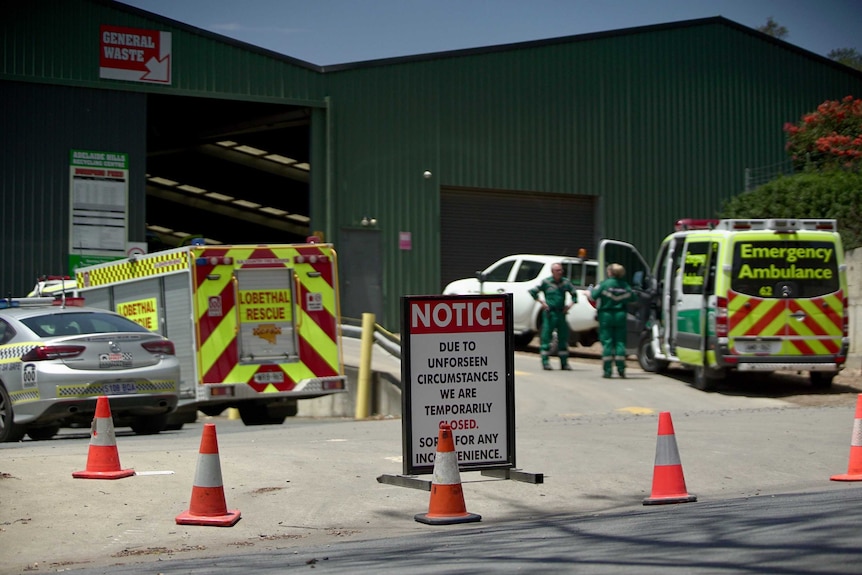 A larged shed with a fire truck, a police car and an ambulance