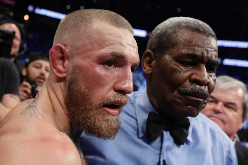 Conor McGregor with the referee after losing to Floyd Mayweather.