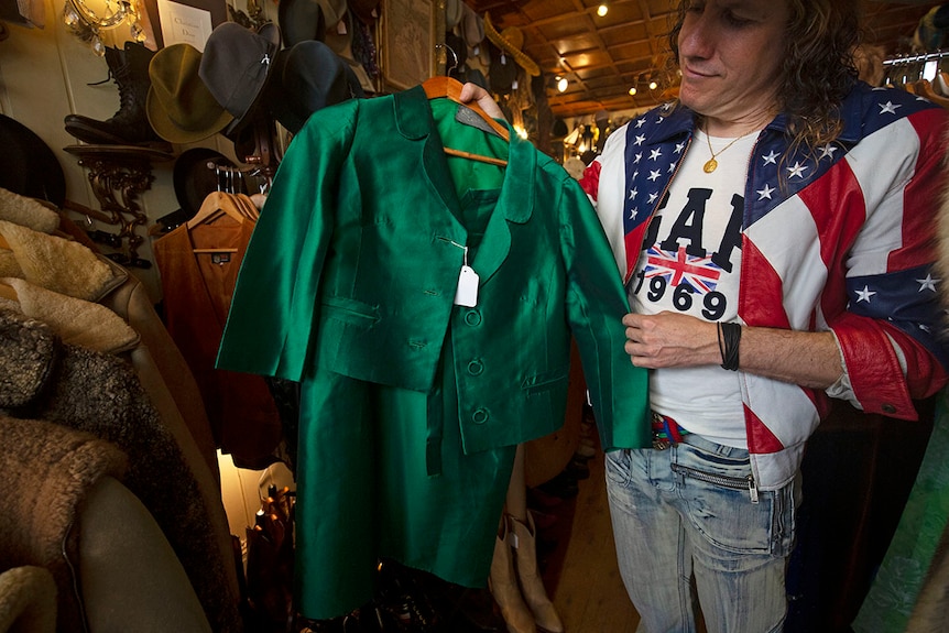 Arnie holds up a green skirt and jacket made by Beril Jents.