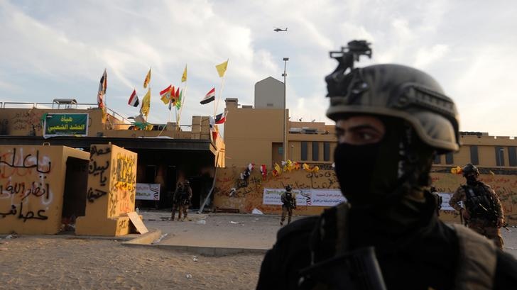 A Iraqi security forces member stands outside the embassy after protesters withdraw.