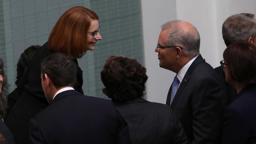 Ms Gillard is smiling at Mr Morrison, on the sideines of the House of Representatives.