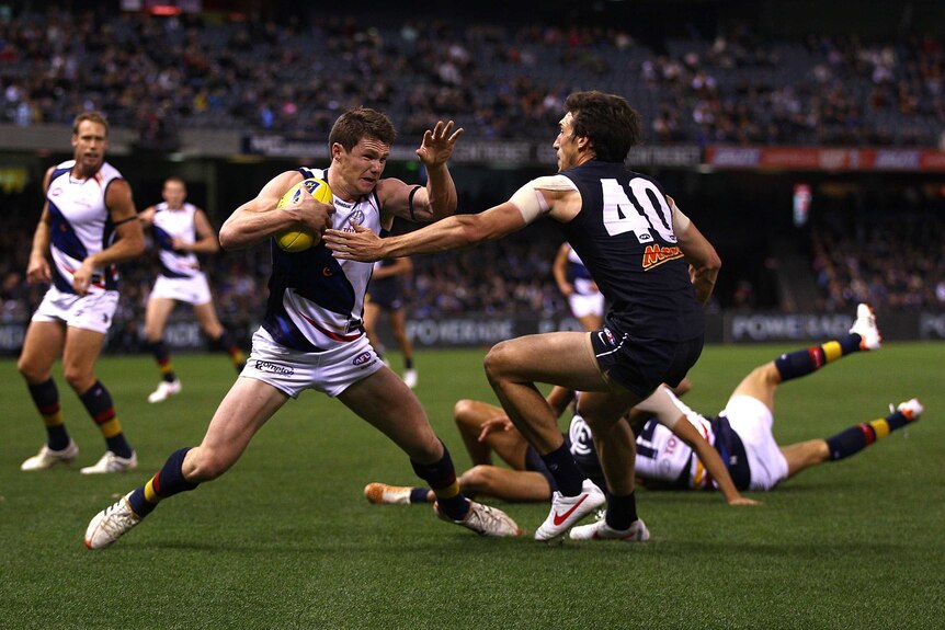 Adelaide's Patrick Dangerfield (L) fends off Carlton's Michael Jamison at Docklands in May 2012.