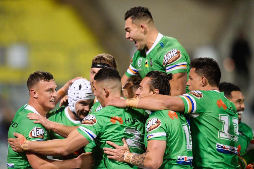 The Raiders surround Jarrod Croker as they celebrate his try against the Sharks.