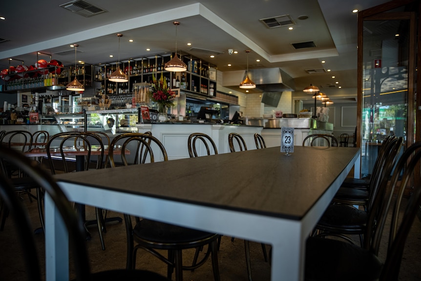 A long empty table at a cafe