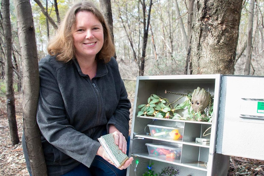 Canberra woman opening a large geocache container