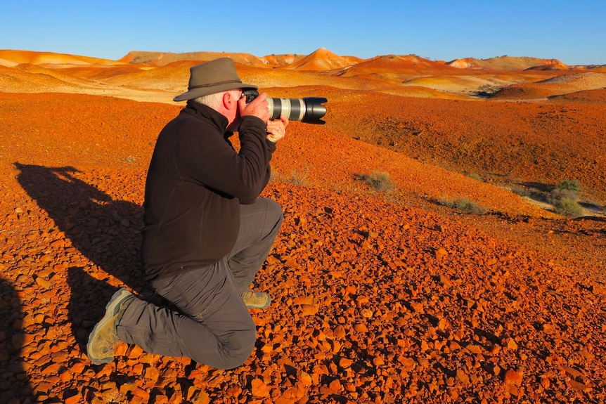 a man taking a photo in the desert