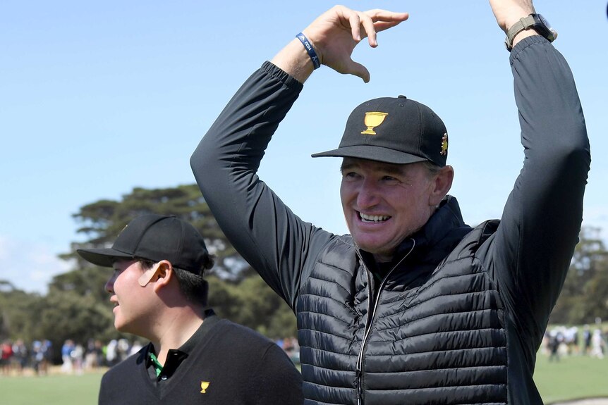 Ernie Els throws his hands up in the air, a gesture to members of the crowd to commence cheering.