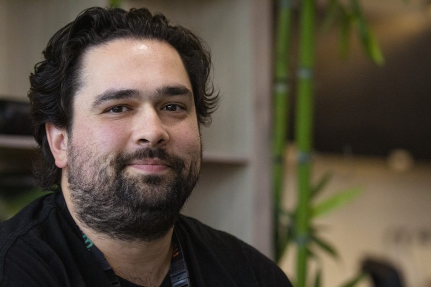 A man with a beard smiling at the camera.