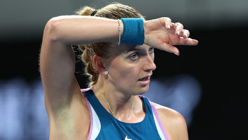 Petra Kvitová wipes her face at the Australian Open