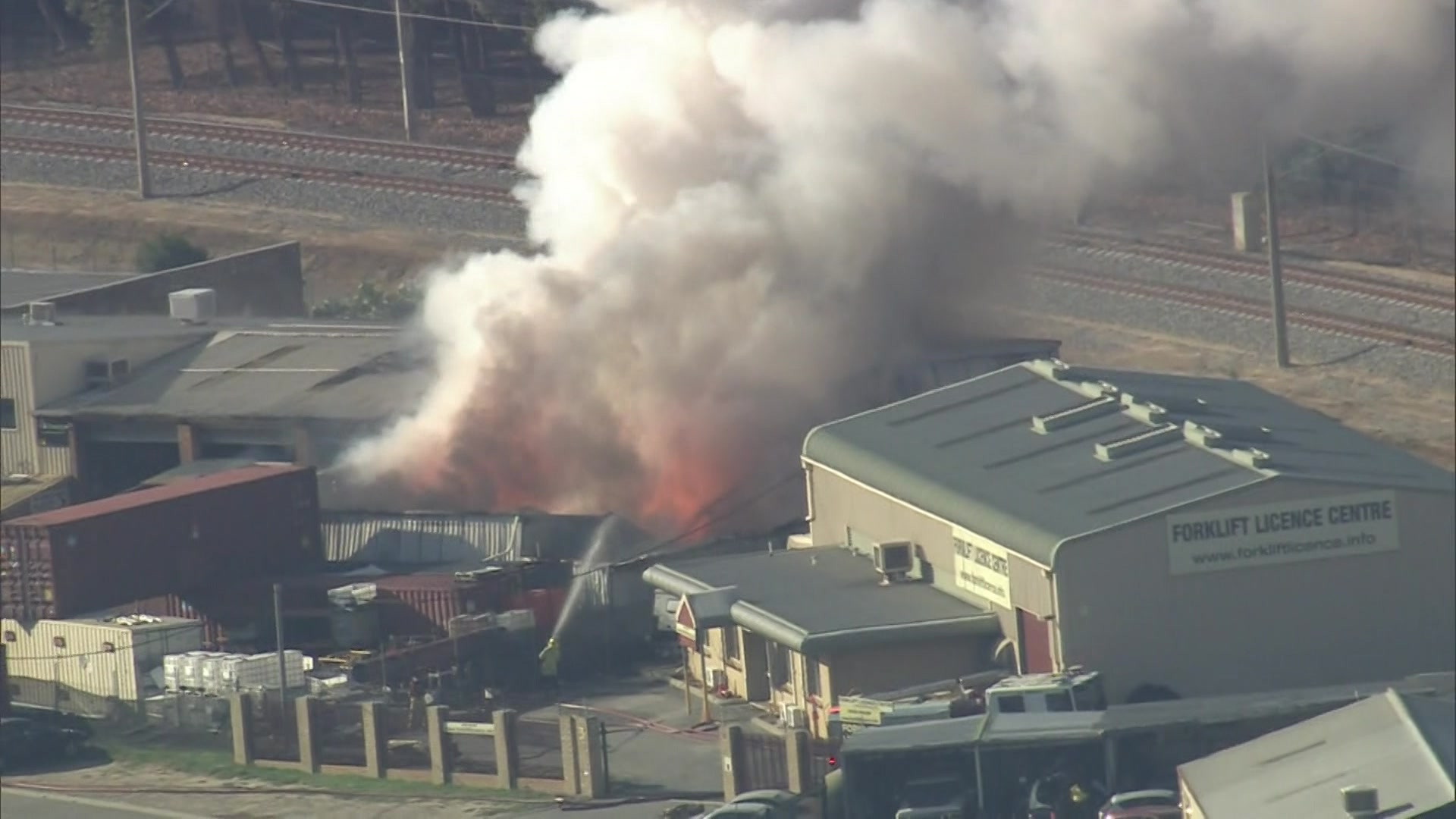 Видно, как пламя вырывается из здания в промышленной зоне. 