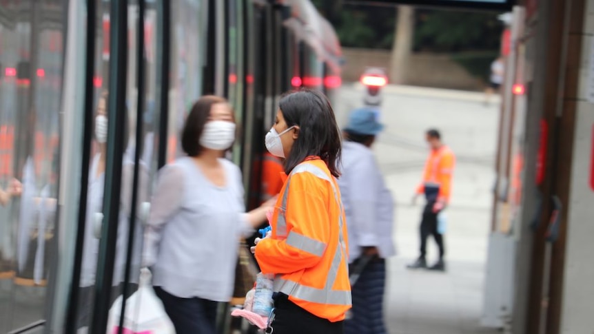 A woman in a mask in a hi-vis long-sleeved shirt