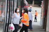 A woman in a mask in a hi-vis long-sleeved shirt