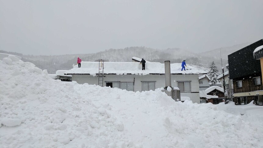 People shovel snow of roof in Nozawa Onsen ski resort