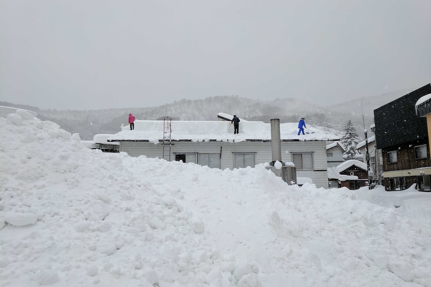 People shovel snow of roof in Nozawa Onsen ski resort