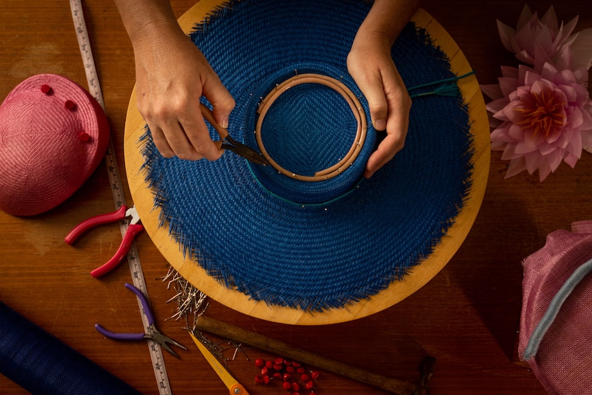 a hat is being made on a bench, it is round and colourful