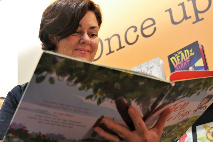 woman reading book from below