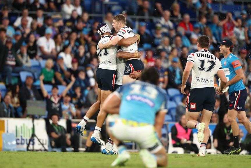 Sam Walker and other Sydney Roosters players jump and hug after beating the Gold Coast Titans in the NRL.