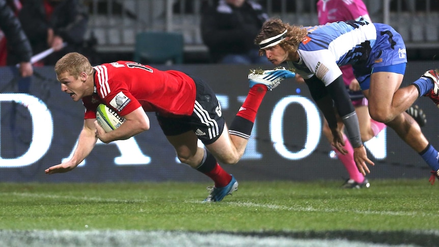 The Crusaders' Johnny McNicholl scores a try ahead of the Western Force's Nick Cummins.
