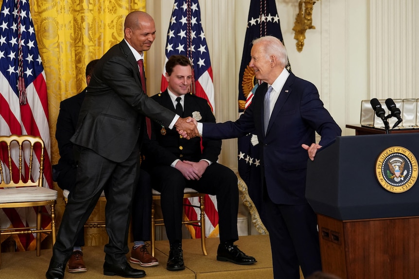 美国总统乔·拜登在颁奖仪式上向美国国会大厦警长阿奎利诺·冈内尔致敬。