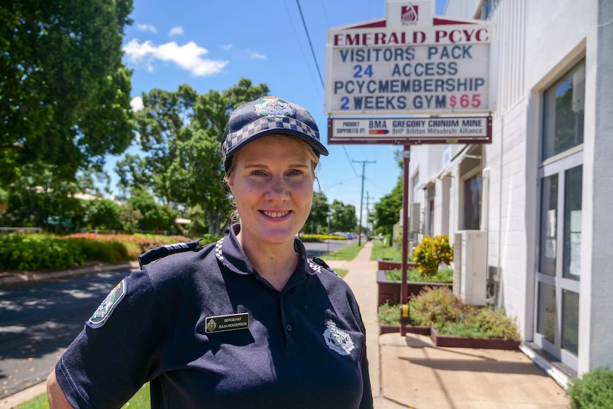 Sergeant Julia Henderson smiles outside the Emerald PCYC building in her Queensland Police Service uniform