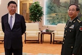General Fang Fenghui stands beside Chinese President Xi Jinping in a large room with lounge chairs.