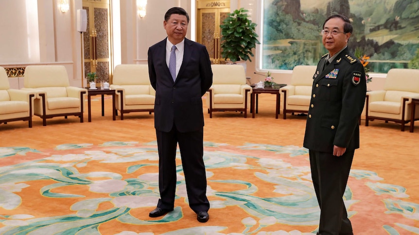 General Fang Fenghui stands beside Chinese President Xi Jinping in a large room with lounge chairs.