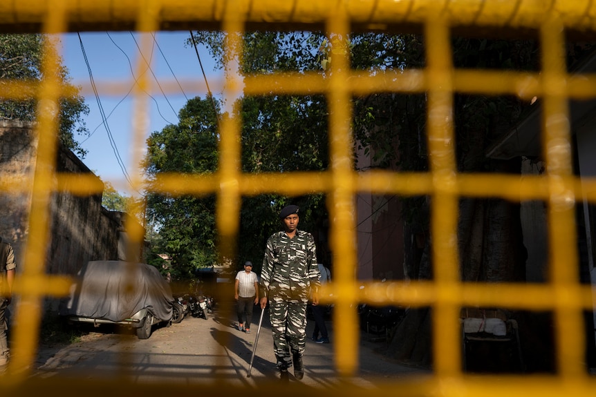 铁丝网后面站立的印度警察。