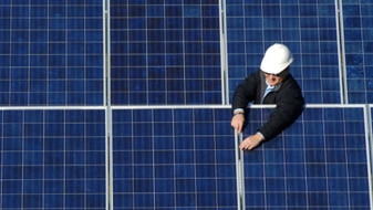 Man working with solar panels (Thinkstock:  iStockphoto)