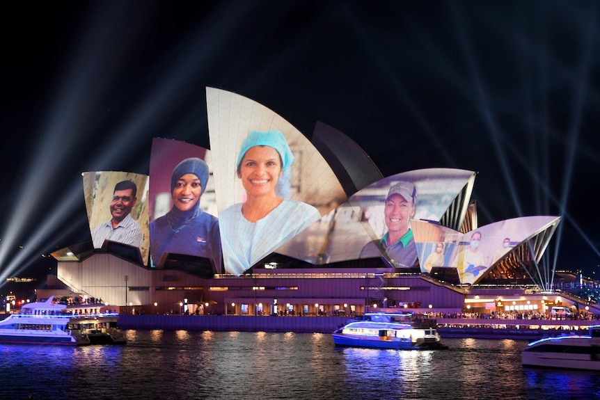 faces of doctors and essential workers projected onto the sails of the Sydney opera house