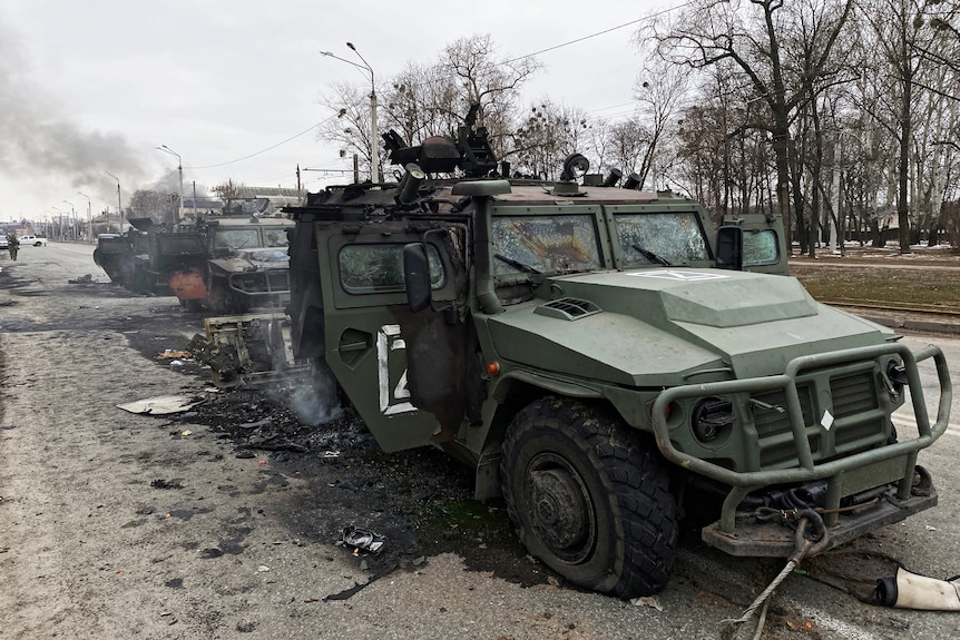 A series of Russian Tigr vehicles partially destroyed on a road in Kharkiv.