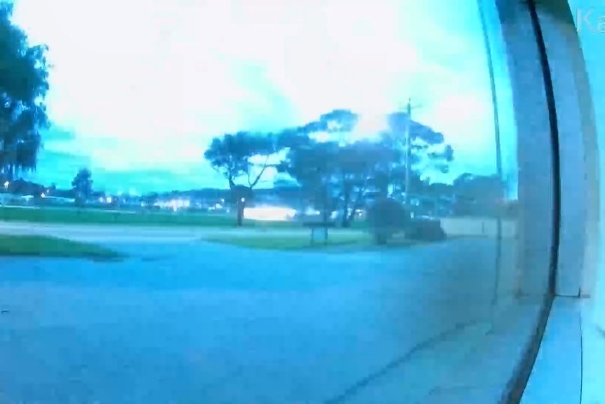 A suburban street illuminated by a flash from a meteor.