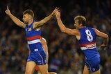 Jake Stringer of the Bulldogs (L) reacts after kicking a goal against the Sydney Swans.