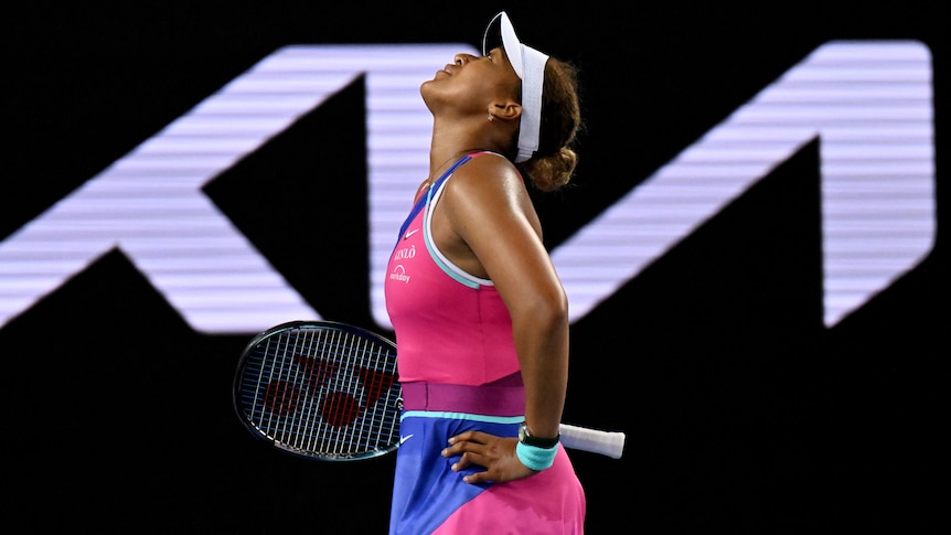 A female tennis player stands with her hands on her hips as she looks up to the sky at the Australian Open.