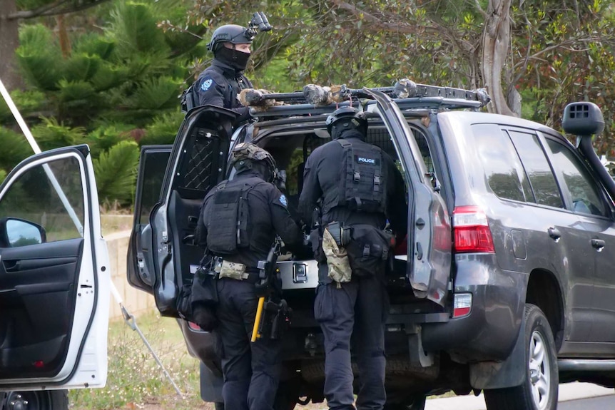 Heavily armed police with masks, near car, with bulletproof vests