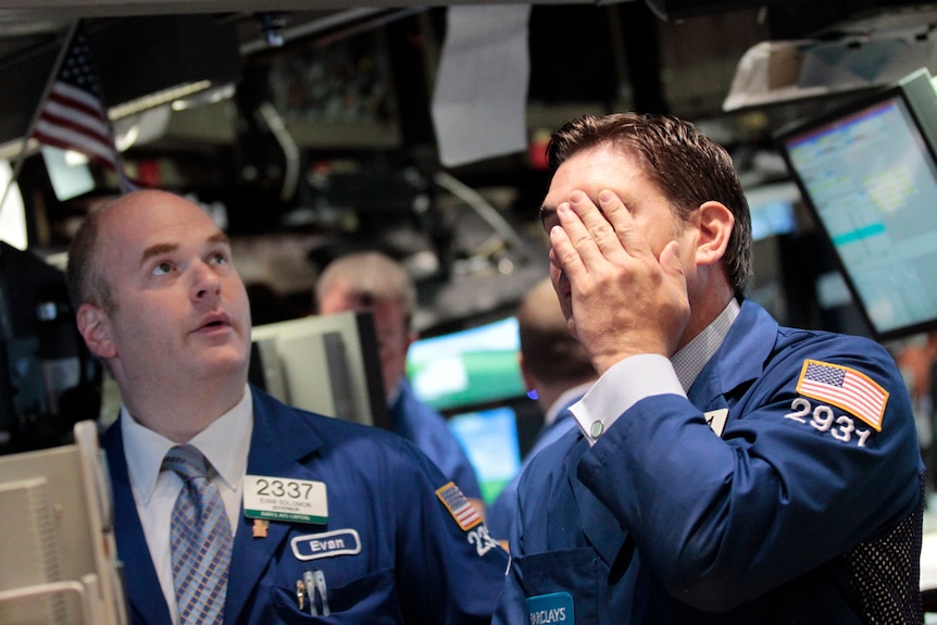 Stressed traders work on the floor of the New York Stock Exchange