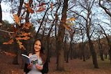 Young woman holding book in the forest