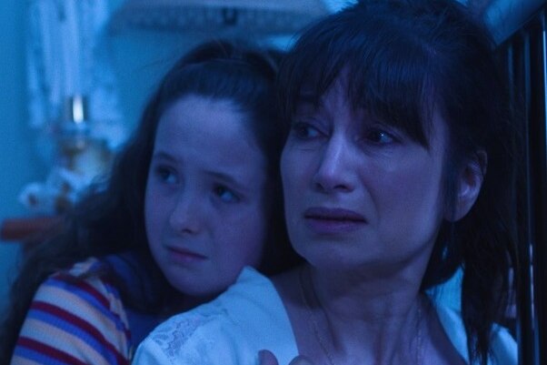 A screen shot of a woman, Frances Duca and a young girl looking distressed