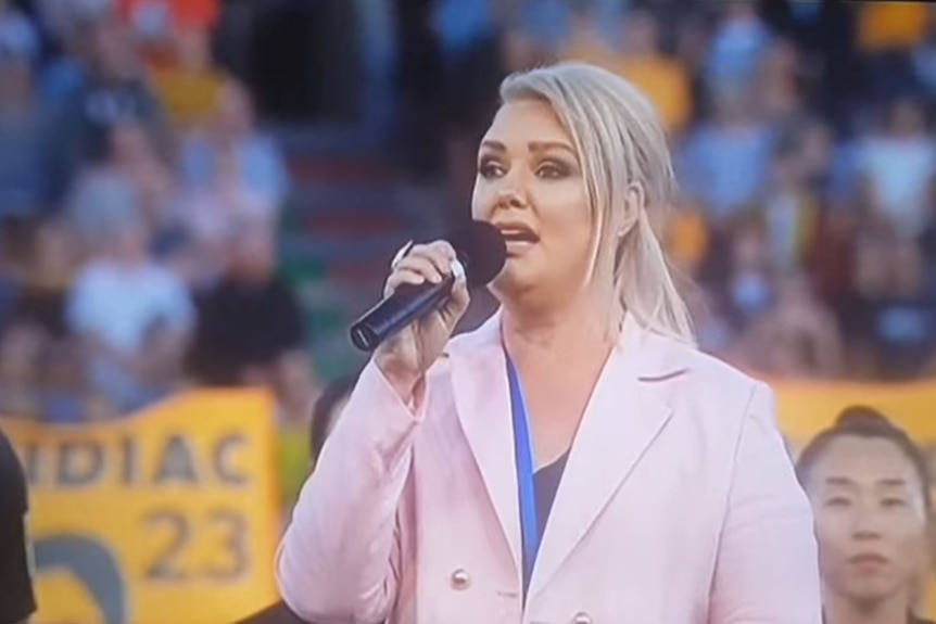 Woman singing with crowd in the background