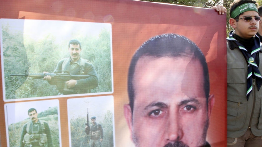 A Hamas support holds a picture of Al Mabhouh at his funeral in Syria.