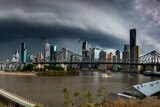 Dark storm clouds loom over a city.