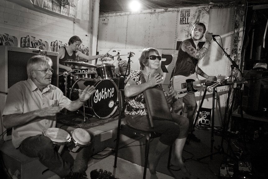 Black and white image of a band called Guthrie joined by an elderly couple playing washboard and bongo drums.