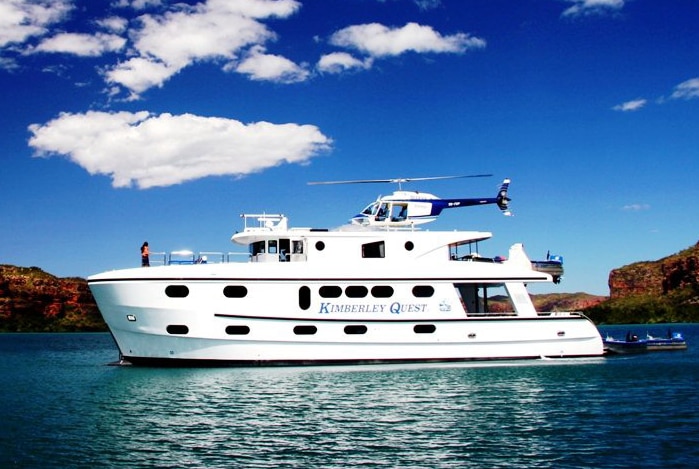 The Kimberley Quest II sits on water off the Broome coast in WA's Kimberley with a helicopter on top.